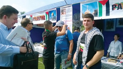 Palestinian young people introduce about their country at the annual Charity Bazaar 2014 at Unis International School in Hanoi on December 23, 2014