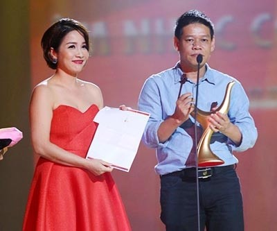 Musician Vo Thien Thanh (R) receives the title of Singer of the year on behalf of My Tam.