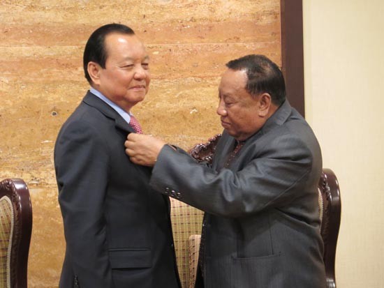 Mr. Phanhdouangchith Vongsa, Chairman of the Central Committee of the Lao Front for national reconstruction (R) confers a medal on marking the 60th anniversary of the founding of the Lao People's Revolutionary Party to Mr. Le Thanh Hai. (Photo: Sggp)