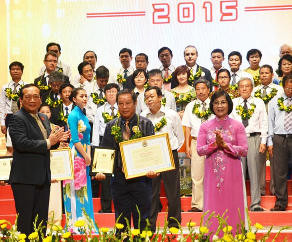 Ms. Thu Ha congratulates enterprises' leaders at the honor ceremony. Photo: SGGP
