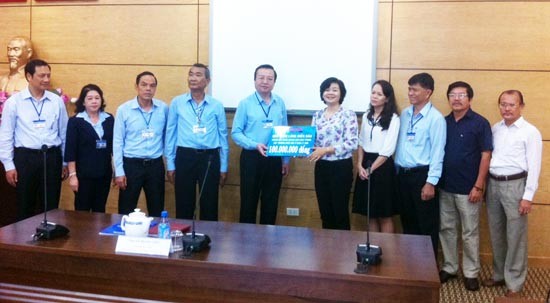Ms. Ly Viet Trung, deputy editor-in-chief of Sai Gion Giai Phong Newspaper, offers VND100 million to Mr. Le Hong Son, director of the HCMC Department of Education and Training (Photo: SGGP)