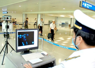 An airport official scans arrivals' temperature to check possible MERS- CoV signs. (Photo:SGGP)