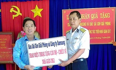 Deputy editor in chief Nguyen Thanh Loi gives gifts to the Naval Battalion DK1 -Photo: SGGP