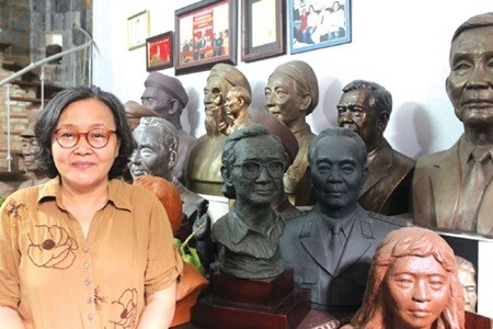 Surrounded by greatness: Sculptor Lai Thi Kim Thanh poses besides her statues of renowned historical figures. — Photo petrotimes.vn