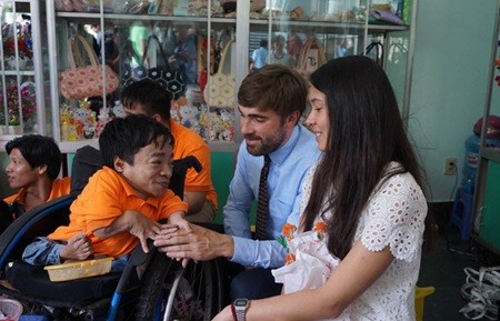 Bertrand Repold, with Amelie Lefebvre next to him, shakes hands with a Vietnamese Agent Orange victim at a meeting with a group of victims at the War Remnants Museum in HCM City last Saturday. — VNS Photo Van Dat