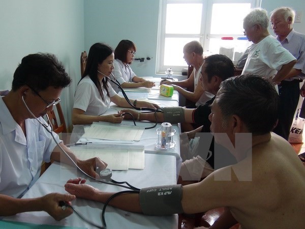 Medical workers give check-ups to AO/dioxin victims (Photo:VNA)