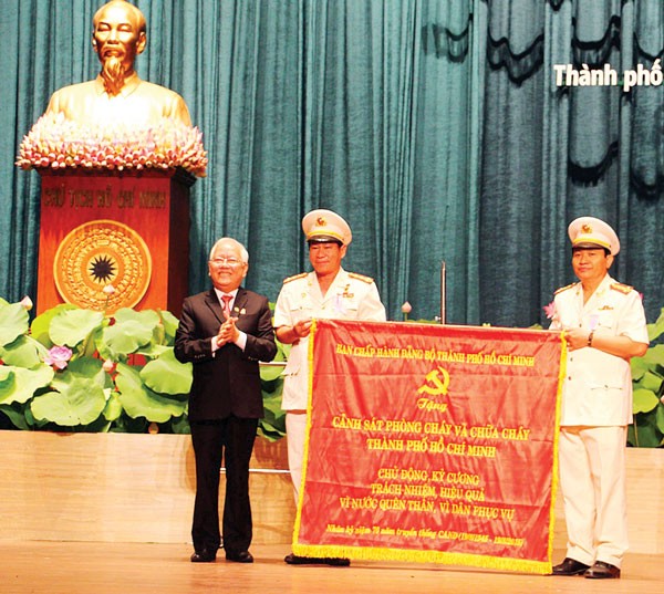 Chairman of HCMC People's Committee Le Hoang Quan grants a certificate of merit to HCMC Public Security and Fire Fighting Police . (Photo:SGGP)