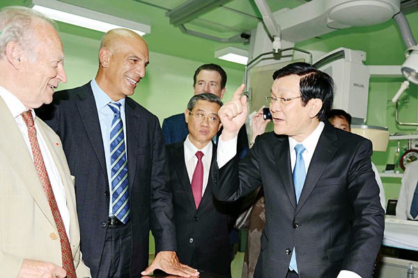 President Nguyen Tan Sang talks to French experts at the ceremony to open the modern heart center (Photo: SGGP)