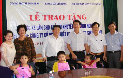 At the ceremony, representatives and sponsors give wheelchairs to disabled children in Nghe An Province (Photo: SGGP)