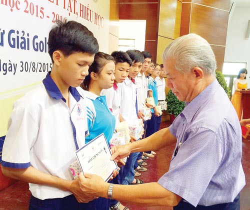 At the scholarship - giving ceremony, Tran Thanh Long , chairman of the Poor Patient Sponsor Association in HCMC gives scholarships to good needy students (Photo: SGGP)
