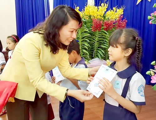 Ms.Nguyen Thi Thu, Chairwoman of HCMC Labor Union gives Nguyen Huu Canh scholarships to students in Cu Chi Dist