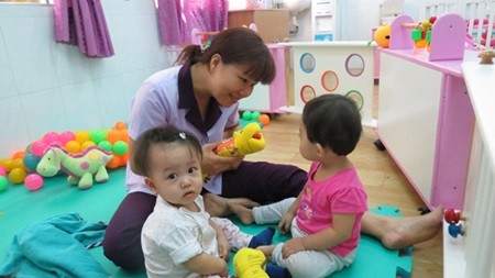 Teacher Tran Thi My Thuy from Rang Dong Kindergarten in HCM City plays with children who are now allowed to be enrolled in public kindergartens that are part of a pilot programme.—VNS Photo Gia Loc
