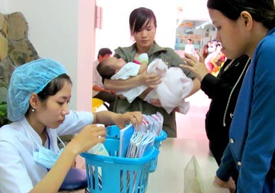 A parent ask for vaccien for their children at a hospital in HCMC (Photo: SGGP)