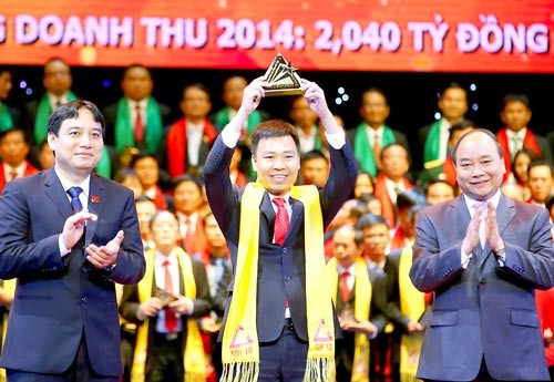 Deputy Prime Minister Nguyen Xuan Phuc (R) and Nguyen Dac Vinh, First Secretary of the Central Committee of the Ho Chi Minh Communist Youth Union (L) give award to businesses. (Photo: Sggp)
