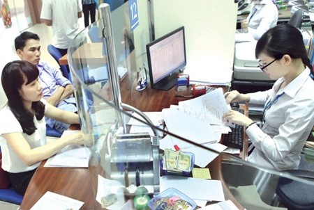 Customers at a transaction desk of a branch of VietinBank in north-eastern Quang Ninh Province's Ha Long City. NA deputies voiced their concern over the proposed changes to the value added tax law and tax administration law yesterday in Ha Noi. (Photo: VNA/VNS)