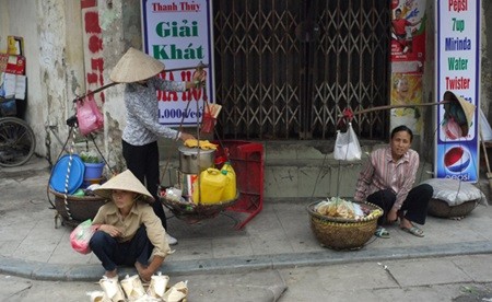 Street vendors in Ta Hien Street, Hoan Kiem District, Ha Noi. As the country is integrating deeper into the world market, a number of street vendors who come to pursue their dream in cities might lose their jobs. — VNS Photo Viet Thanh