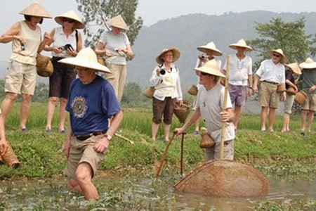 Tourists enjoy outdoor activities during their homestay tour in Van Long district in Ninh Binh province (Source:VNS/VNA)
