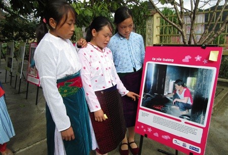Vu Thi Vu (center) shows her friends one of her photos on display at Can Chu Phin secondary school in Meo Vac District, Ha Giang Province. — VNS Photo Bach Lien