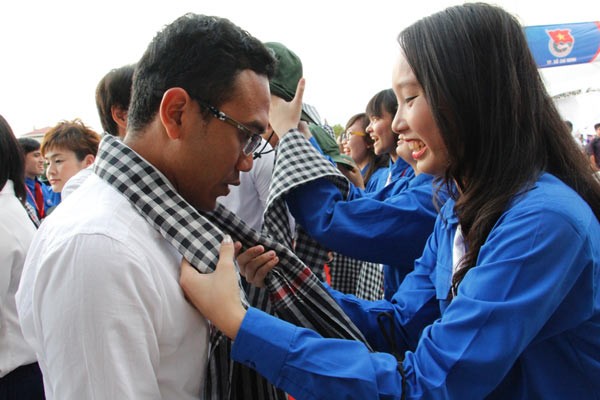 The city’s young people offer bandana for international friends at the welcome ceremony.(Photo:SGGP)