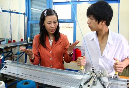 A deaf student follows his tutor to practise on a weaving machine at the Lam Dong Vocational School in the Central Highland Lam Dong Province.– VNA/VNS Photo Qui Trung