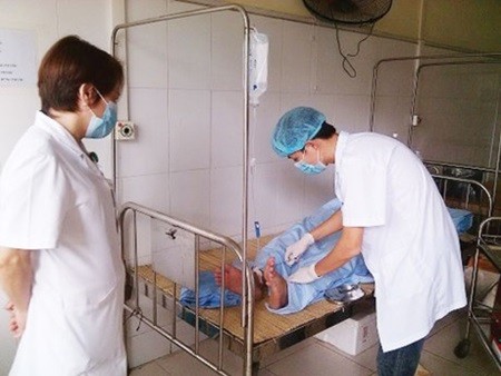 Health workers take care for a people living with HIV. Staff at health facilities continue to face a fairly high risk of infections from body fluids, blood or pathogens as protective measures are not effective. — Photo baohaiquan.vn