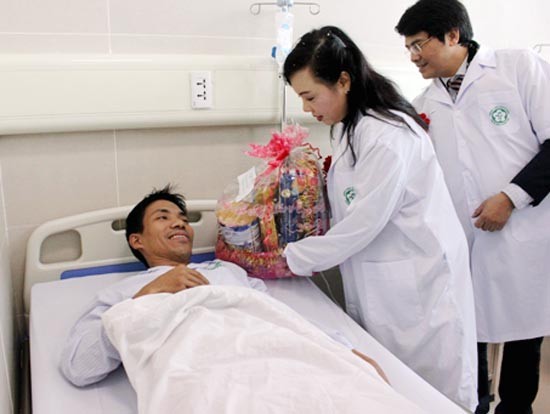 Health Minister Nguyen Thi Kim Tien gives a gift to a patient in Bach Mai Hospital (Photo: SGGP)