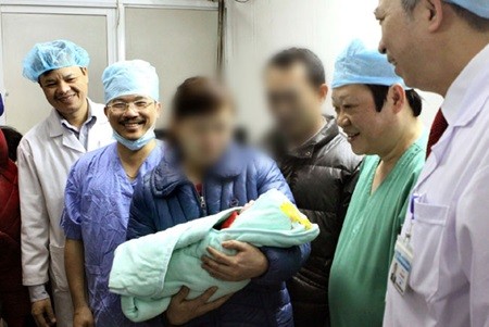 Deputy Minister of Health Professor Nguyen Viet Tien (second from right) and the parents of the first surrogate baby born in Viet Nam. — VNA/VNS Photo Duong Ngoc