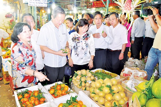 Deputy Chairman Le Van Khoa (3rd, L) inspects Tet goods supply at wholesale markets in HCMC on February 4 (Photo: SGGP)