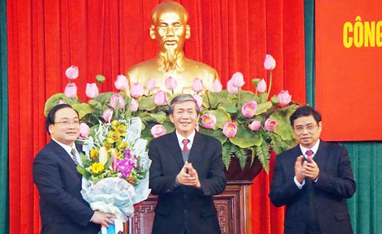 Politburo member Dinh The Huynh (C) gives the Decision appointing Deputy Prime Minister Hoang Trung Hai to be Secretary of the Hanoi Party Committee