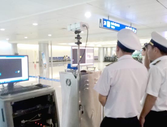 Medical workers keep an eye on passengers' body temperature through Tan Son Nhat Airport (Photo: SGGP)