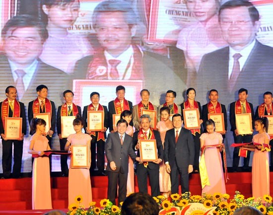 President Truong Tan Sang and chairman of the HCMC People’s Committee Nguyen Thanh Phong give awards to businesses winning the High Quality Vietnam Goods title for the last 20 years at a ceremony in HCMC on February 23 (Photo: SGGP)