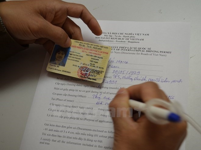 Filling the application form for an International Driving Permit -Photo: VNS