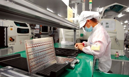 An employee works on an electronic spare parts production line at Synopex Viet Nam Co., Ltd, funded by South Korea, in Ha Noi's Quang Minh Industrial Zone. The Viet Nam-Korea Free Trade Agreement Support Centre opened in Ha Noi yesterday. — VNA/VNS Photo Danh Lam