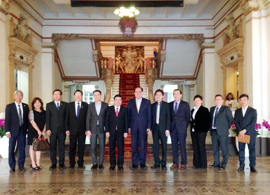 Chairman of the HCM City's People's Committee Nguyen Thanh Phong (6th from left) poses in a photo with representatives from Ascendas-Singbridge group (Photo: Sggp)
