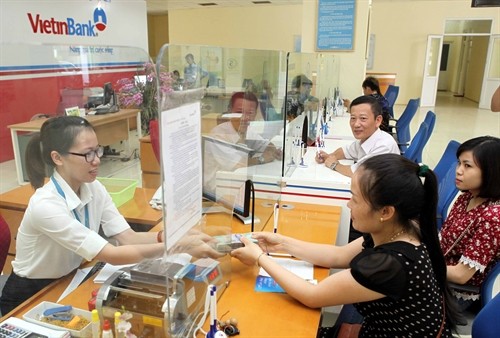 Customers make a transaction at a VietinBank branch in Sơn La Province. The central bank set a cap of 5.5 per cent per year for short-term deposits of less than six months and floated the rate for medium- and long-term deposits. - VNA/VNS Photo Trần Việt