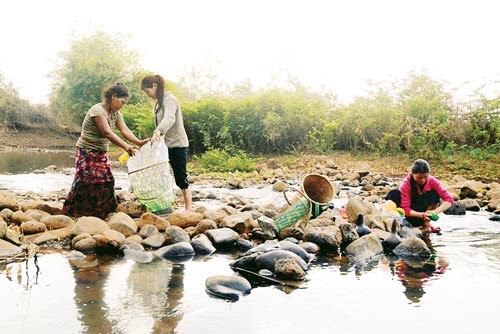 Residents at HVet 1 Hamlet in Ayun commune of Chu Se District in the central highlands province of Gia Lai take water from Pet stream for daily use - Photo: SGGP