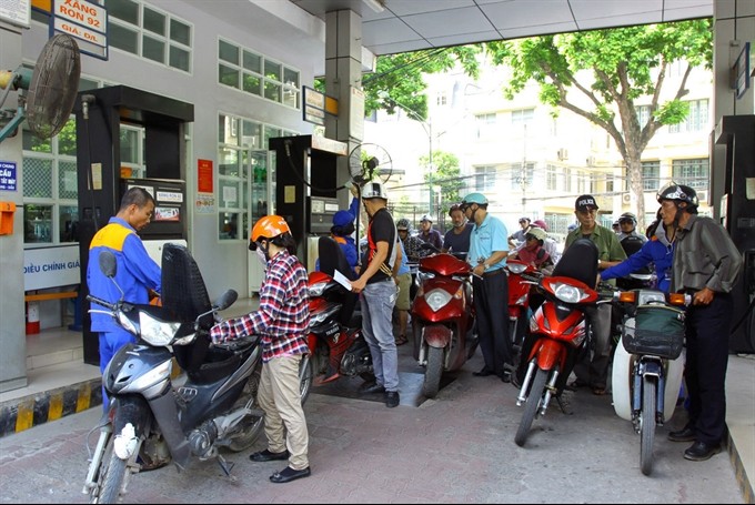 Customers buy petrol at a station in Hanoi -VNS