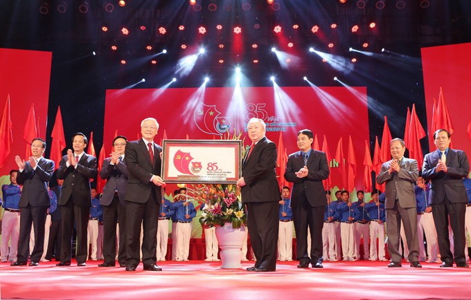 Party General Secretary Nguyễn Phú Trọng presents a picture to congratulate youths nationwide at a ceremony held to mark the 85th founding anniversary of the Hồ Chí Minh Communist Youth Union yesterday.