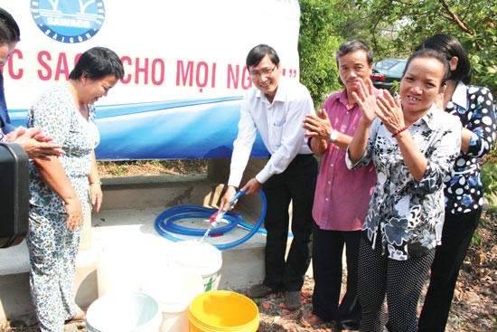 Residents show their happiness when fresh water station is installed in residential blocks (Photo: SGGP)