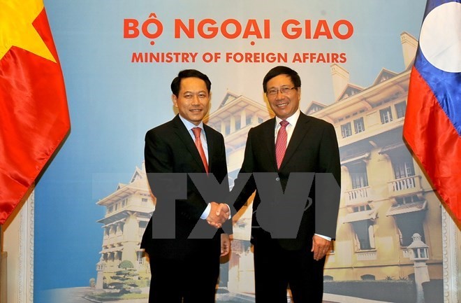 Deputy Prime Minister and Foreign Minister Pham Binh Minh (R) and Lao Foreign Minister Saleumxay Kommasith (Source: VNA)