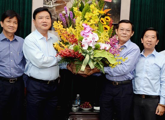 Secretary Dinh La Thang gives flowers to editor-in-chief of SGGP Nguyen Tan Phong (Photo: SGGP)