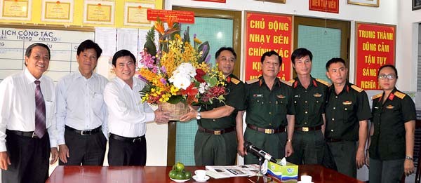 Chairman of HCMC People's Committee Nguyen Thanh Phong (the third from left) offers flower to editoral board and reporters of Newspaper of 7th Military Zone. (Photo: SGGP)