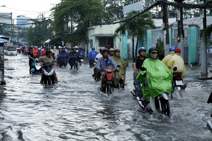 Khuong Viet Street in District 11, HCM City floods with heavy rain, causing chaos for residents moving around the city. The city has started its biggest ever anti-flooding project to control tidal flooding and chronic flooding. (Photo: VNA/VNS)