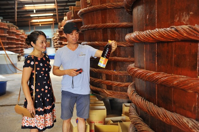 Customers shop for Phú Quốc fish sauce, a speciality of Phú Quốc Island in the southern province of Kiên Giang. Registration of geographical indications will help local firms protect trademarks, improve their position in the world market and easily enter demanding markets. — VNA/VNS Quang Hải