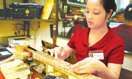 A staff at Bảo Tín Minh Châu Jewelry Company’s shop in Hà Nội. Gold price hits a high level on July 6. — File Photo