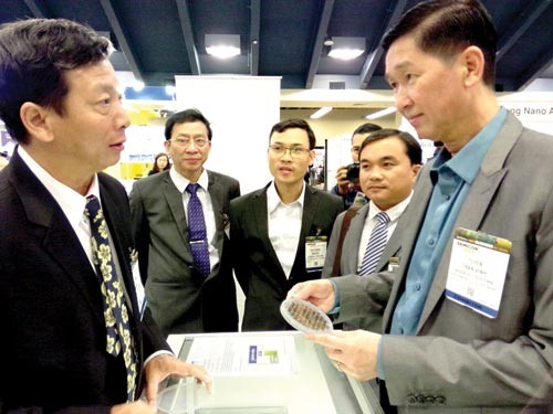 Deputy Chairman of HCMC People’s Committee Mr. Tran Vinh Tuyen (first R) visits Vietnam's stall of semiconducting chip product. (Phpto:SGGP)