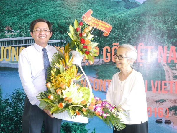 Chairman of Binh Dinh Province People's Committee, Ho Quoc Dung offers flowers to Professor Le Kim Ngoc. (Photo: Sggp)
