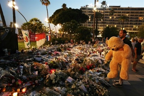 France National Assembly votes to extend state of emergency A man holds a giant teddy bear in front of a makeshift memorial near the Promenade des Anglais in Nice. - AFP/VNA Photo