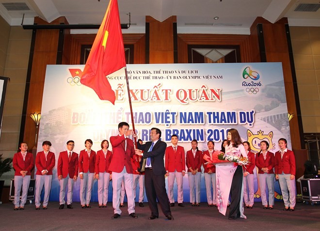 Vietnam Chief of Mission Tran Duc Phan (left) receives the national flag from Minister of Culture, Sports and Tourism Nguyen Ngoc Thien during a sending-off ceremony on July 20 (Photo: VNA)