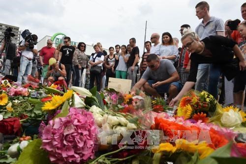 People in Munich city, Germany, are laying flowers in commemorating victims of the shooting on July 23. (Source: AFP/VNA)